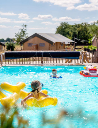 Children playing in the pool at FarmCamps Hoeve Luyterheyde holiday park in North Brabant, Netherlands.