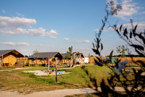 Cabañas y zona de juegos en FarmCamps Hoeve Luyterheyde, parque vacacional en Brabante Septentrional, Países Bajos.