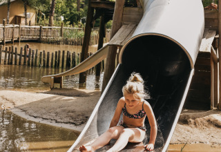 Un bambino scende da uno scivolo di metallo al Camping het Horstmannsbos, parco vacanze in Drenthe, Paesi Bassi.