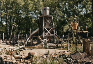 Wooden playground area with a tower and slide at Camping het Horstmannsbos holiday park, Drenthe, Netherlands.