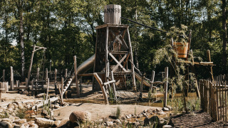 Zona de juegos de madera con torre y tobogán en Camping het Horstmannsbos, Drenthe, Países Bajos.