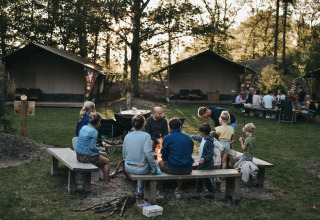 Famiglie riunite attorno a un falò a Camping het Horstmannsbos, un villaggio vacanze a Drenthe, Paesi Bassi.
