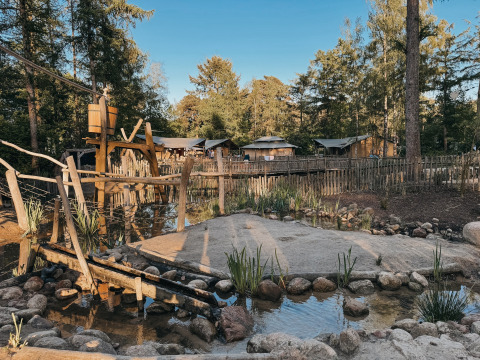 Spielplatz und Holzunterkünfte im Camping het Horstmannsbos, einem Ferienpark im grünen Drenthe, Niederlande.