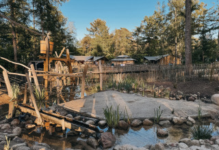 Wooden play area and safari tents at Camping het Horstmannsbos holiday park in Drenthe, Netherlands, forest view.