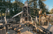 Area giochi con torre di legno, scivolo e acqua al Camping het Horstmannsbos, Drenthe, Paesi Bassi.