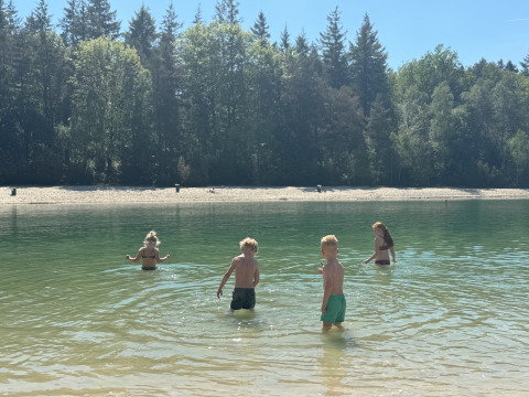 Kinder spielen im Wasser am Camping het Horstmannsbos, umgeben von Wald in Drenthe, Niederlande.