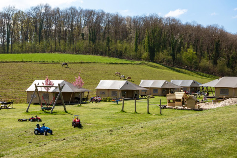 Foto de FarmCamps De Verloren Kost en Limburgo, Países Bajos con tiendas, área de juegos y campos verdes.