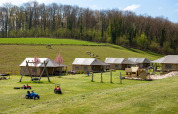 Billede af FarmCamps De Verloren Kost i Limburg, Holland med telte, legeredskaber og grønne marker.