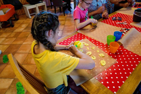 Kinder schneiden Zutaten bei einer Kochaktivität im FarmCamps Five Star Ferienpark in Zeeland.