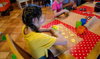 Kinder schneiden Zutaten bei einer Kochaktivität im FarmCamps Five Star Ferienpark in Zeeland.