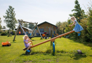 To børn leger på en vippe på FarmCamps Fleur Stables, en ferielejr på landet i Nordholland, Holland.