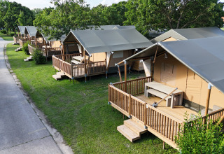 Fila di tende glamping moderne con veranda in legno a Camping Terme Catez, Slovenia.