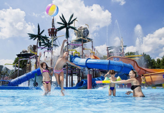 Kids and adults play in a water park with slides and fountains at Camping Terme Čatež holiday park, Slovenia.