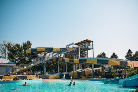 Water slide and swimming pool at Camping Terme Catez holiday park in Slovenia on a sunny day.
