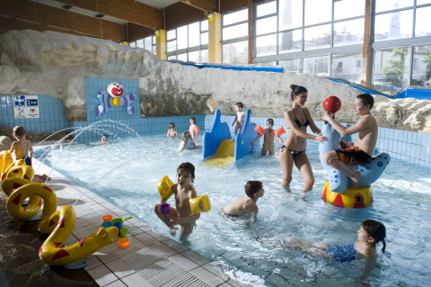 Indoor kids pool with toys, slides, and children playing at Camping Terme Catez holiday park, Slovenia.