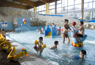 Indoor kids pool with toys, slides, and children playing at Camping Terme Catez holiday park, Slovenia.