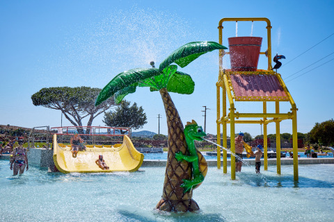 Bambini che giocano sugli scivoli e giochi d’acqua al Camping Village Baia Blu La Tortuga in Sardegna, Italia.