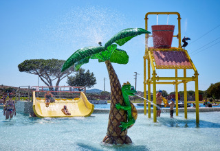 Children play on a water slide and interactive water features at Camping Village Baia Blu La Tortuga in Sardinia, Italy.