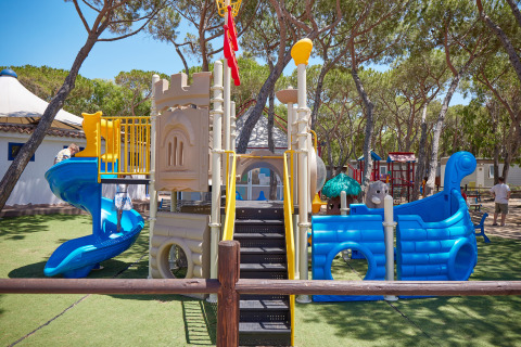 Parco giochi con scivoli e strutture al Camping Village Baia Blu La Tortuga in Sardegna, Italia.