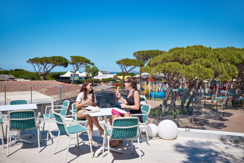 Due donne gustano un gelato sulla terrazza con vista sul Camping Village Baia Blu La Tortuga in Sardegna, Italia.