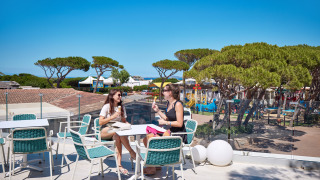 Dos mujeres disfrutan helado en una terraza con vistas a Camping Village Baia Blu La Tortuga en Cerdeña, Italia.
