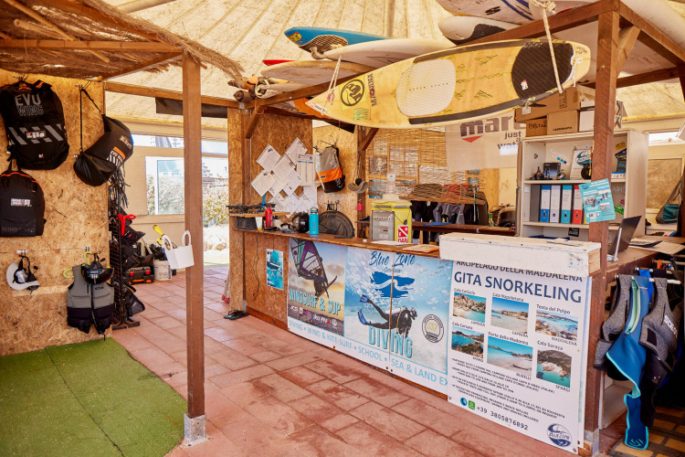 Boutique d'équipement nautique au Camping Village Baia Blu La Tortuga en Sardaigne, avec planches et matériel de plongée.