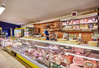 Comptoir traiteur au Camping Village Baia Blu La Tortuga, Sardaigne, avec fromages et charcuteries.