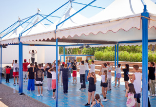 Lezione di danza per grandi e piccoli sotto la tettoia al Camping Village Baia Blu La Tortuga, Sardegna.