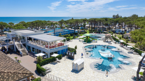 Luchtfoto van Camping Village Cavallino in Veneto, Italië, met zwembaden en zeezicht op de achtergrond.