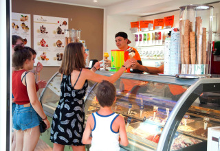 Persone che ordinano il gelato al bancone del Camping Village Cavallino nel parco vacanze in Veneto, Italia.
