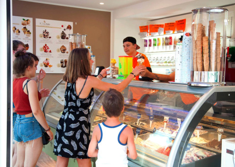 Menschen kaufen Eis an einer Theke im Camping Village Cavallino Ferienpark in Venetien, Italien.