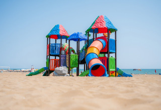Farverigt legeplads på stranden med rutsjebaner og tårne på Camping Village Cavallino i Veneto, Italien.