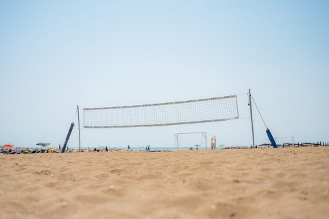 Cancha de voleibol de playa en Camping Village Cavallino, Véneto, Italia, con vista al mar y ambiente veraniego.