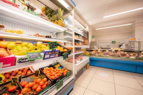 A supermarket at Camping Village Cavallino in Veneto, Italy with fresh fruits, vegetables and a deli counter.