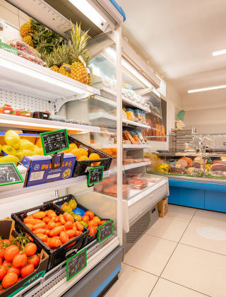 Un supermercado con frutas frescas, verduras y una charcutería en Camping Village Cavallino, Véneto, Italia.