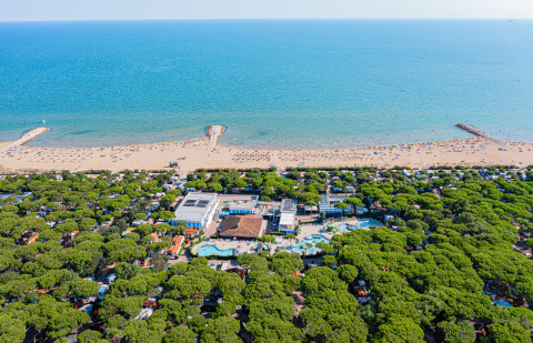 Vista aerea di Camping Village Cavallino in Veneto, Italia, con villaggio, pineta, piscine e spiaggia.
