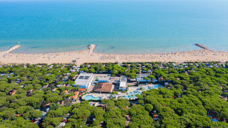 Vista aerea di Camping Village Cavallino in Veneto, Italia, con villaggio, pineta, piscine e spiaggia.