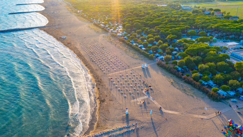 Luftaufnahme des Camping Village Cavallino in Venetien, Italien, mit Strand, Meer und Campingbereich bei Sonnenuntergang.