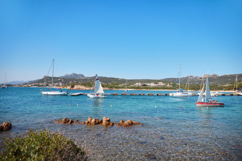 Veleros anclados junto al Centro Vacanze Isuledda en Cerdeña, Italia, en un día soleado y despejado.