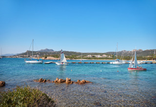 Veleros anclados junto al Centro Vacanze Isuledda en Cerdeña, Italia, en un día soleado y despejado.