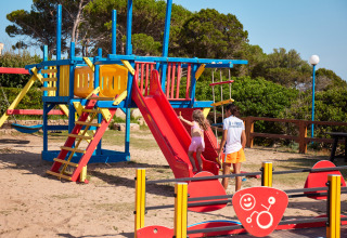 Børn leger på en farverig legeplads i Centro Vacanze Isuledda, en feriepark i Sardinien, Italien.