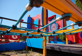 Bunter moderner Spielplatz mit Kletternetz im Centro Vacanze Isuledda, Sardinien, Italien.