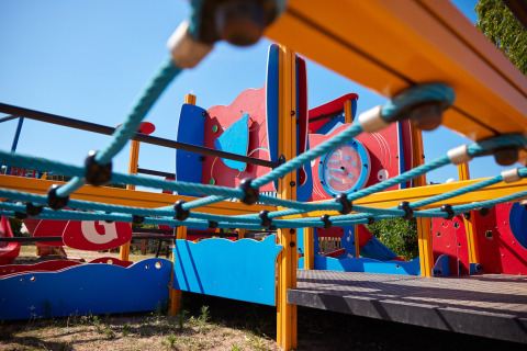 Colorido parque infantil moderno con red de escalada en Centro Vacanze Isuledda, Cerdeña, Italia.