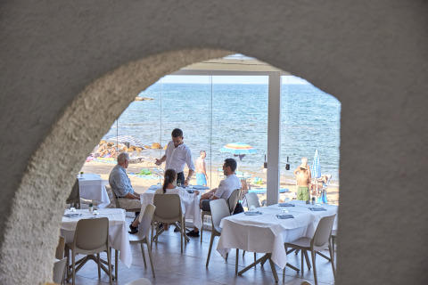 Uitzicht op gasten in een restaurant aan zee in vakantiepark Centro Vacanze Isuledda, Sardinië, Italië.