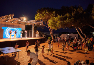 Animazione serale al Centro Vacanze Isuledda in Sardegna, con ballerini sul palco e ospiti davanti.