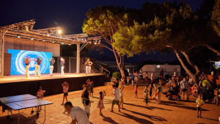 Espectáculo nocturno en Centro Vacanze Isuledda, Cerdeña, con bailarines en el escenario y público.
