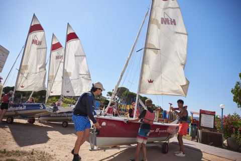 Ospiti preparano barche a vela al Centro Vacanze Isuledda, villaggio turistico in Sardegna, Italia, al sole.