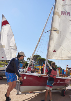 Huéspedes preparan veleros en Centro Vacanze Isuledda, un parque vacacional en Cerdeña, Italia, bajo el sol.