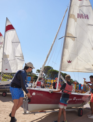 Huéspedes preparan veleros en Centro Vacanze Isuledda, un parque vacacional en Cerdeña, Italia, bajo el sol.