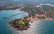 Vista aerea del Centro Vacanze Isuledda in Sardegna, Italia, con spiaggia, mare e porto turistico.